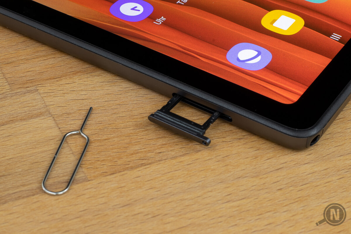 SIM-Karten-Einschub eines mobilfunkfähigen Tablets, links daneben ein Werkzeug zum Öffnen des SIM-Slots.