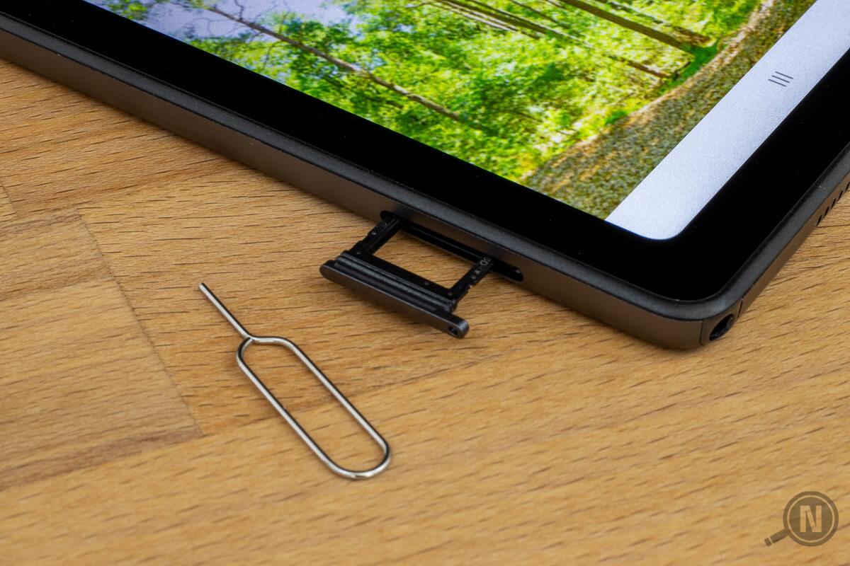 Ecke eines Tablets mit herausgezogenem SIM-Slot, daneben ein kleines Werkzeug zum Öffnen des Einschubs aus gebogenem Draht