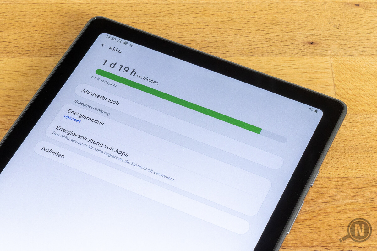 Tablet auf Holztisch, die Akku-Detailanzeige ist geöffnet. Der Akku ist zu 87 Prozent geladen, was durch einen grünen Ladebalken angezeigt wird.
