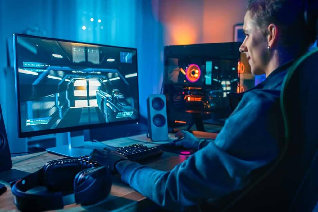 Person spielt Cpmputerspiel an 4K-Monitor