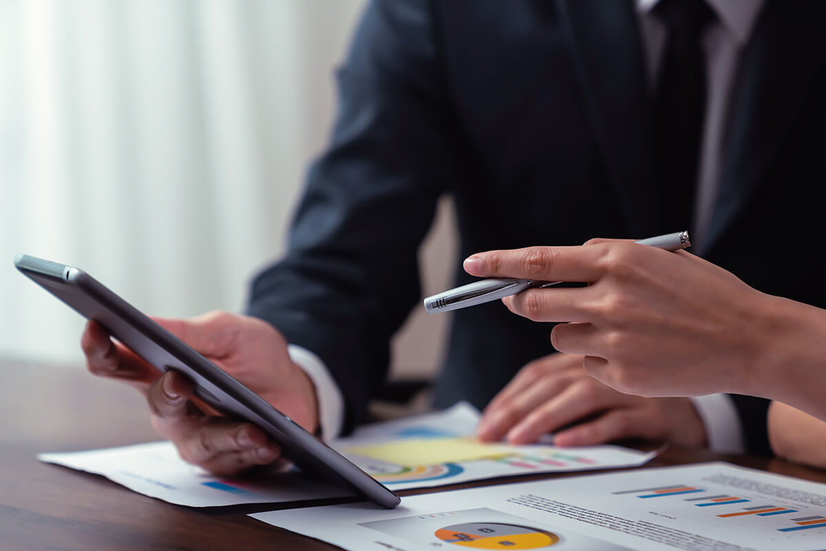 Zwei Personen arbeiten mit einem Tablet in einem Business Setting