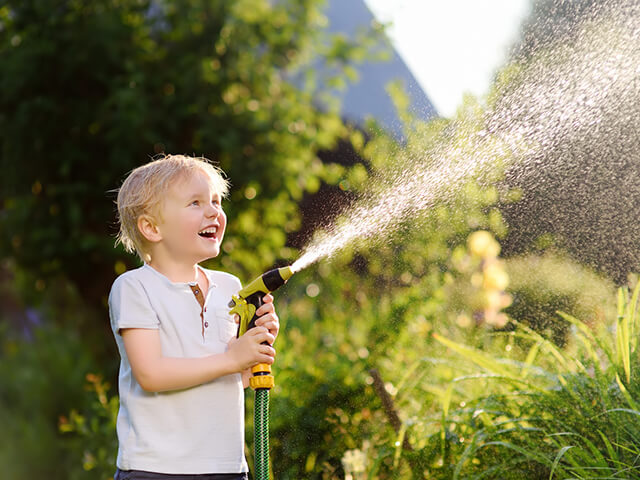Kind mit Wasserschlauch