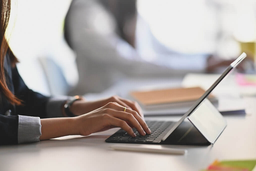 Frau benutzt Tablet mit Tastatur