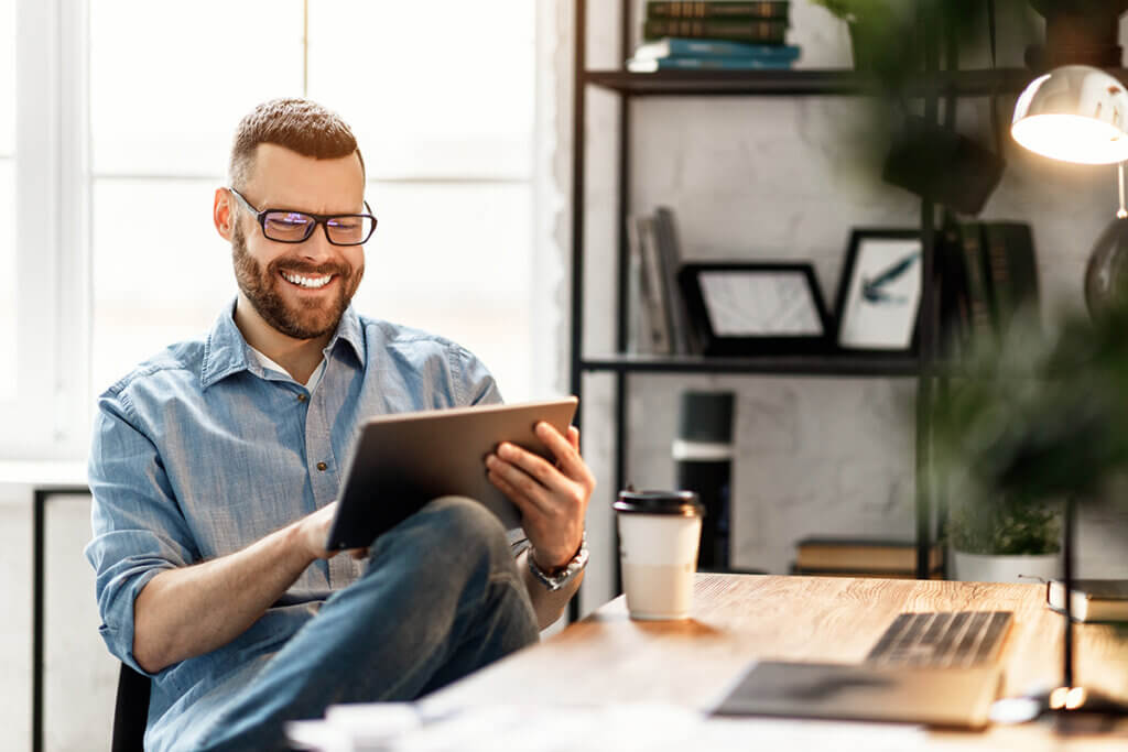 junger Mann im Büro mit Tablet in der Hand