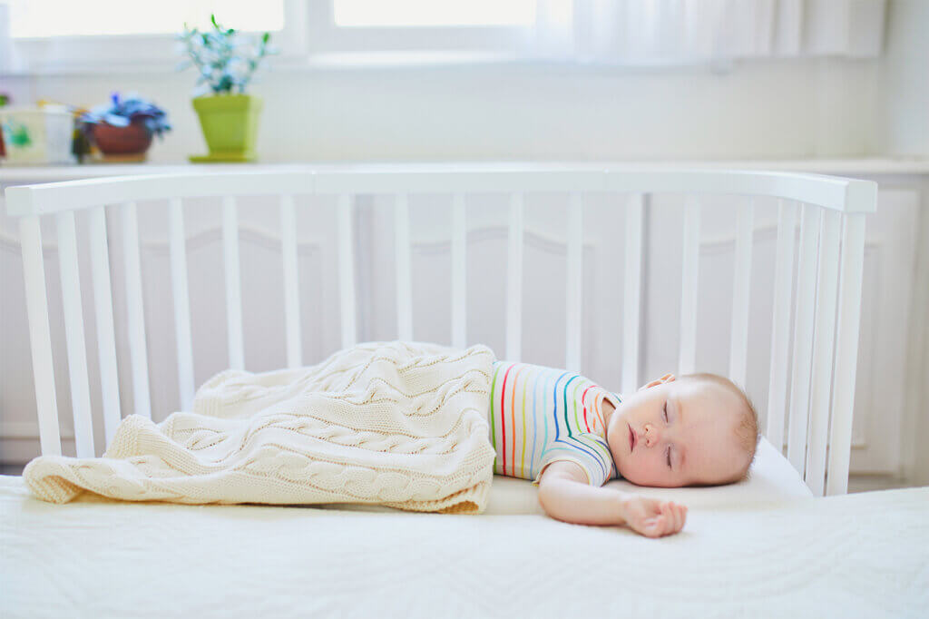 baby schlaeft in beistellbett