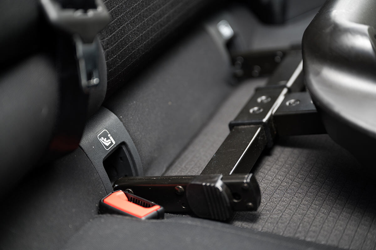 Isofix-Haken werden in entsprechende Halterungen auf der Rückbank im Auto geschoben