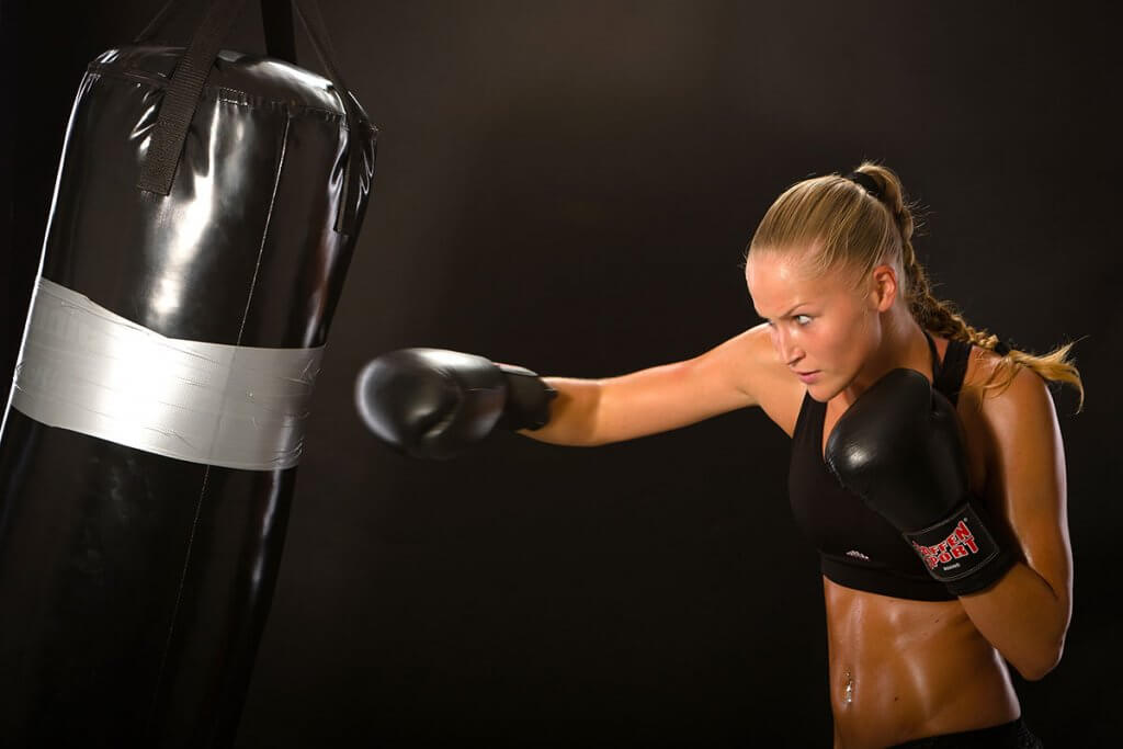 Boxerin mit schwarzem Boxsack beim Training
