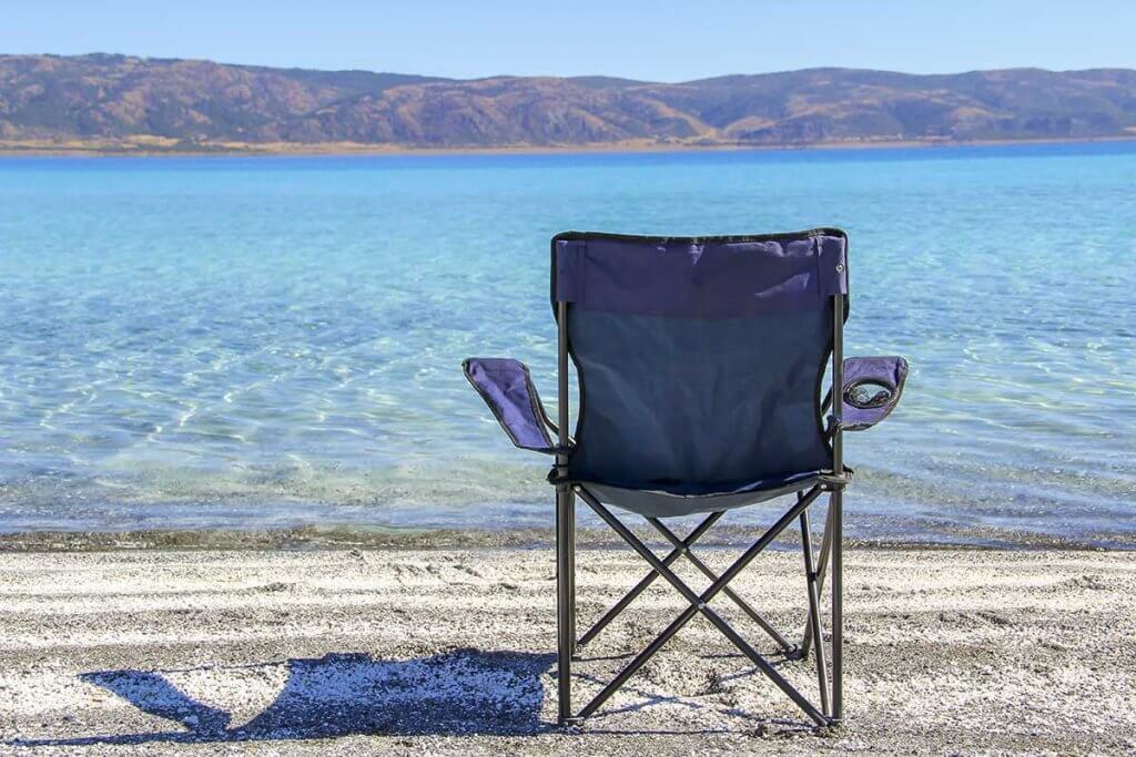 Blauer Faltstuhl am Strand. 