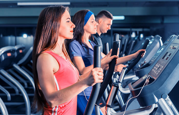 mehrere Personen auf Crosstrainer im Fitnessstudio