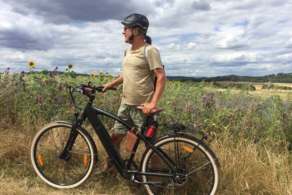 Mann fährt mit E-Bike über Feld
