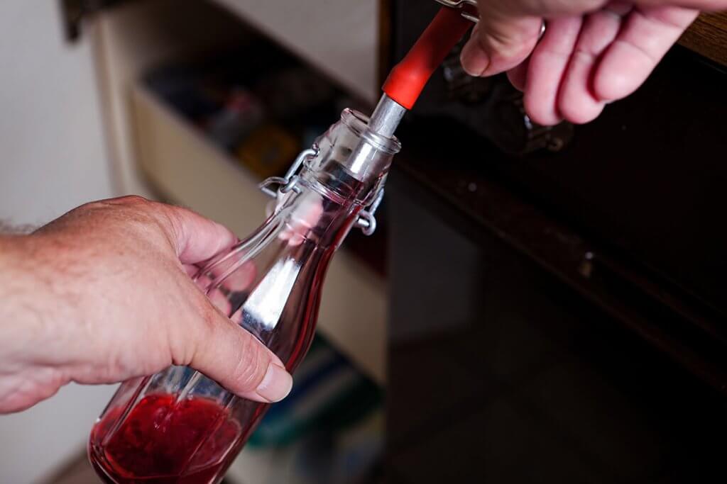 flasche wird mit johannisbeerensaft aus dem dampfentsafter befuellt