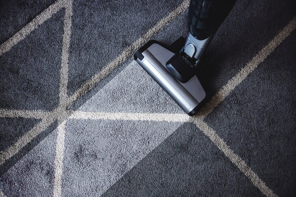 Dampfreiniger auf grauen Teppich