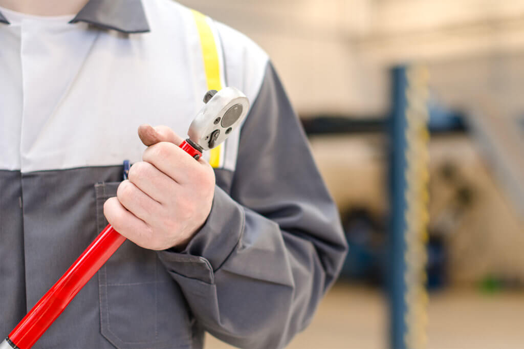 Mechaniker hält Drehmomentschlüssel in der Hand