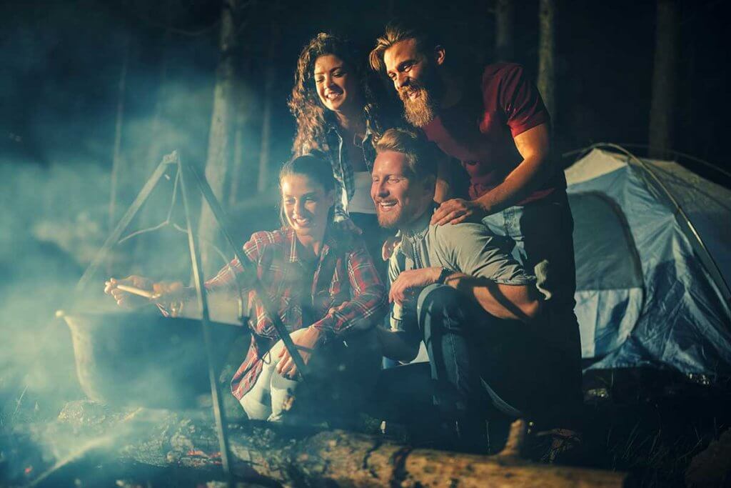 Freunde beim Campen nutzen Dutch Oven