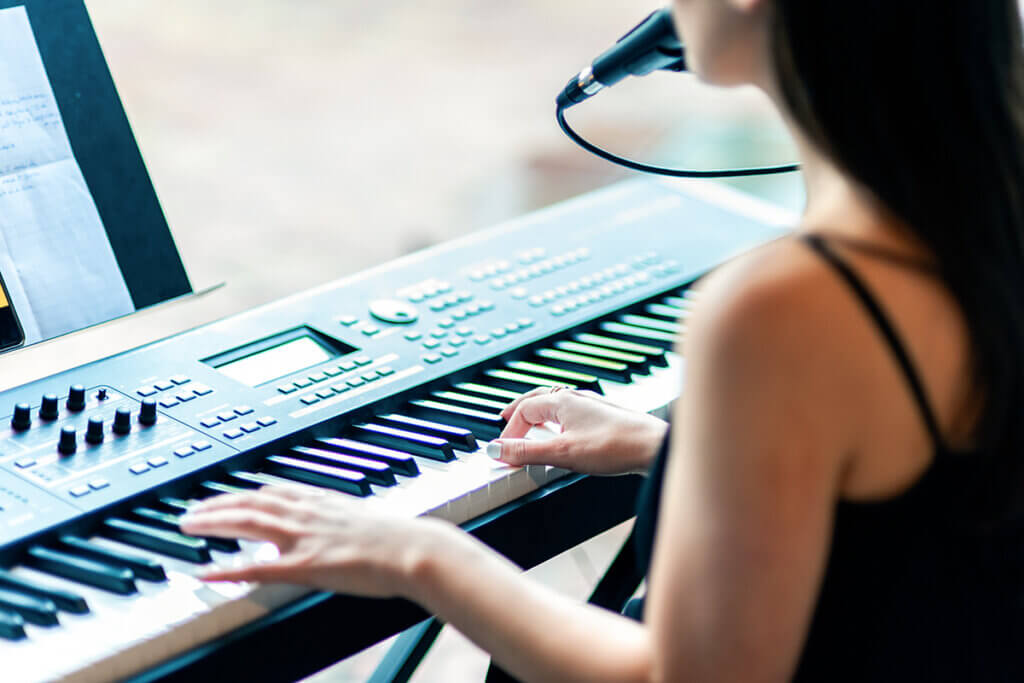 junge Frau spielt an E-Piano