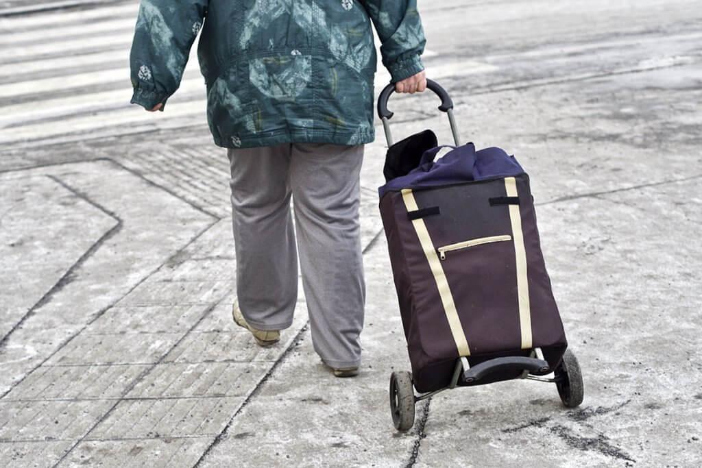 Frau zieht Trolley hinter sich her