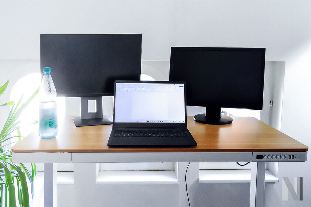 laptop und zwei monitore auf hoehenverstellbarem schreibtisch comhar