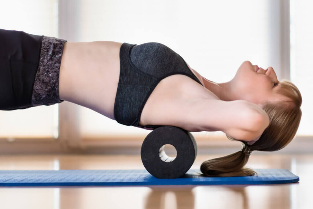 Frau beim Training mit Faszienrolle