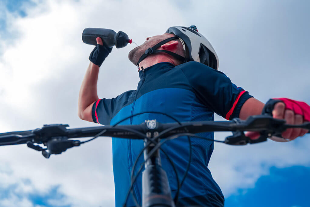 Mann beim Biken trinkt Wasser