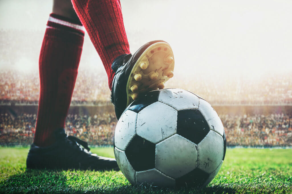 Fußballer mit Ball im Stadion