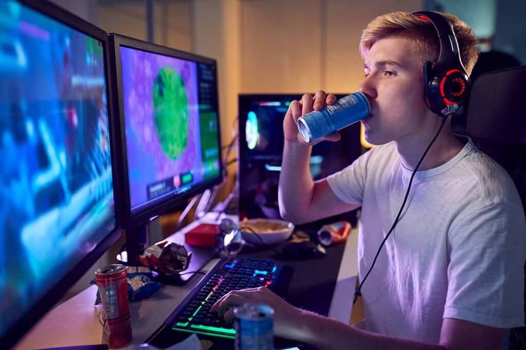 Gamer zockt und trinkt Energydrink