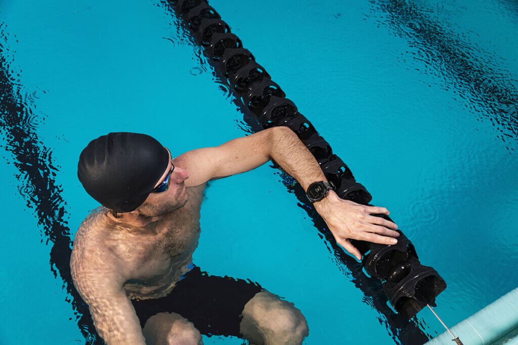 Schwimmer schaut auf Smartwatch