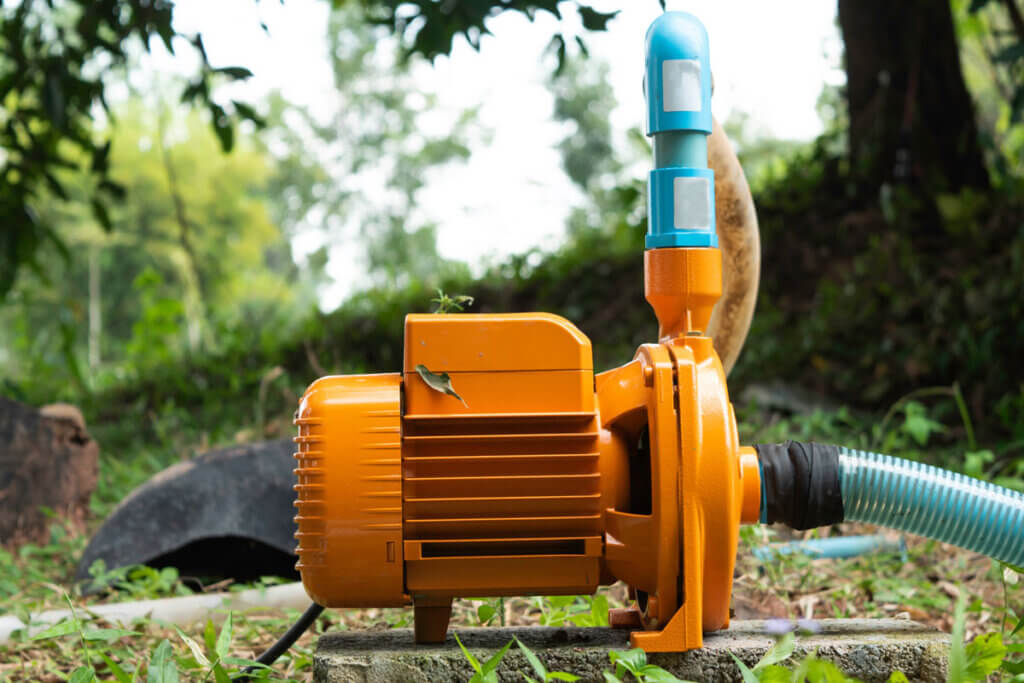 Eine Gartenpumpe mit deutlich erkennbarem Saugschlauch sowie Foerderschlauch