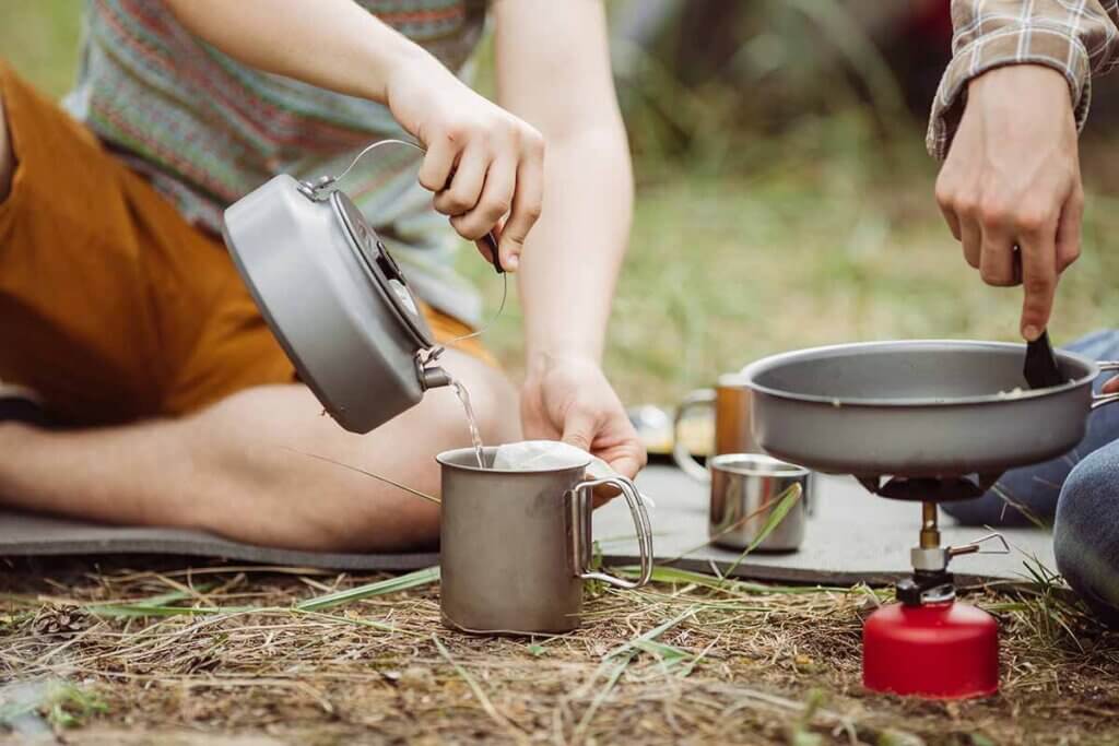 Camper bereiten Tee und Essen zu