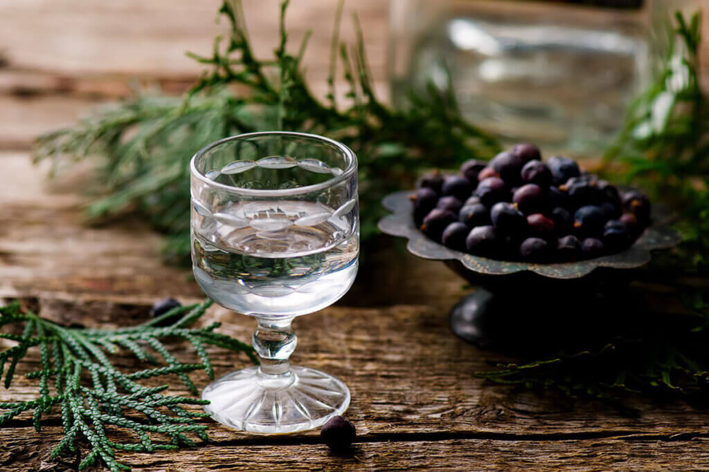 gin auf holztisch mit wachholder