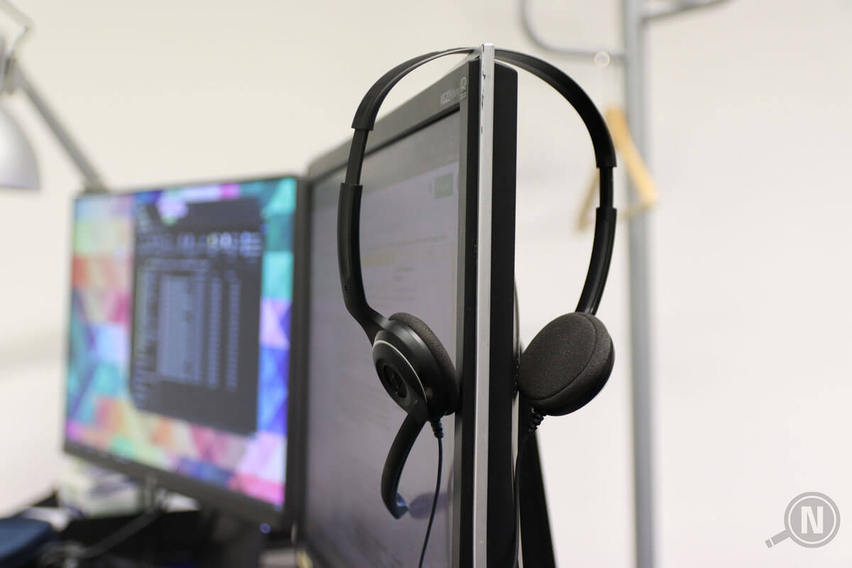 Seitlicher Blick auf Bildschirm, an dem ein Headset hängt