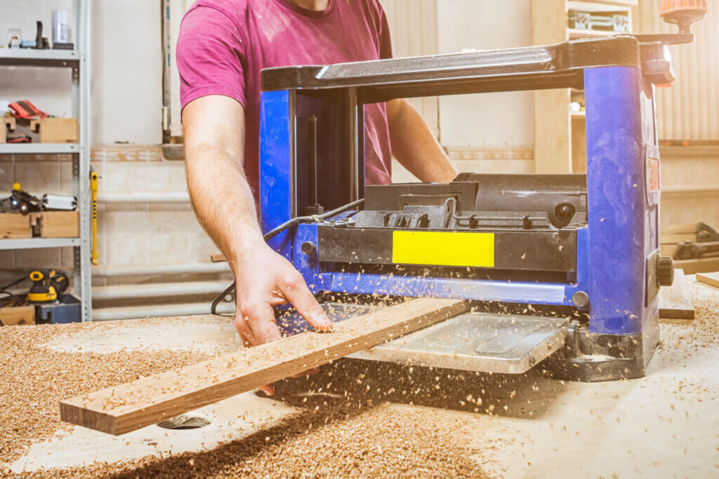 holzbrett wird mit hobelmaschine geholbelt