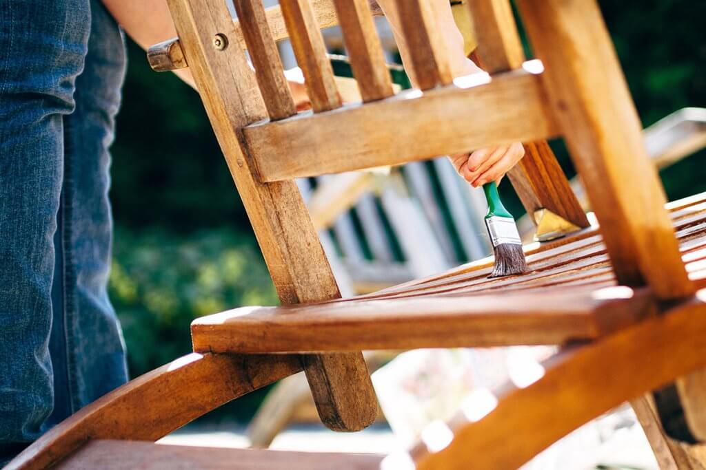 Holzmoebel auf Terrasse werden lasiert