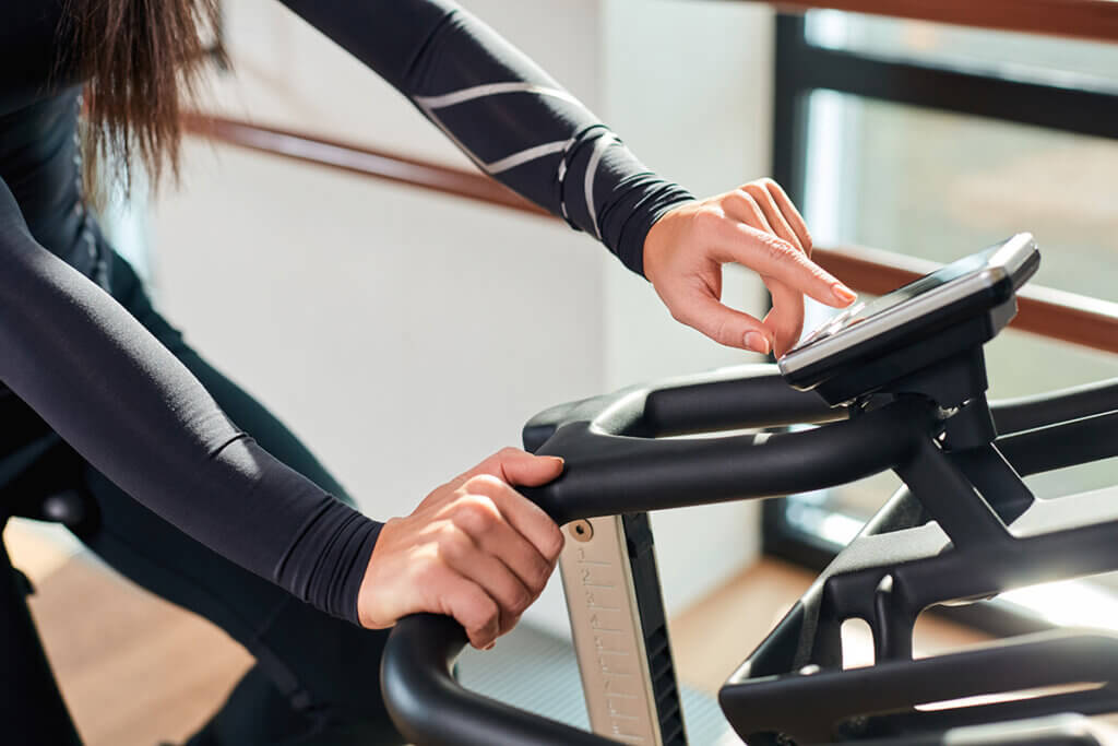 Frau beim Trainieren stellt Bike ein