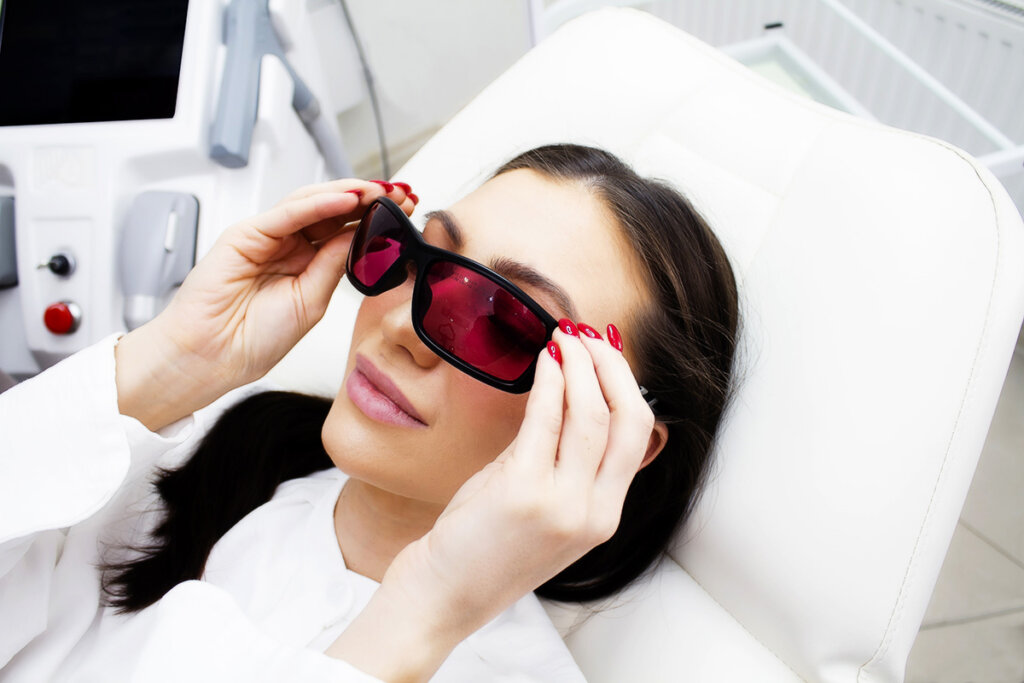 Frau im Behandlungsraum zur Haarentfernung mit Schutzbrille