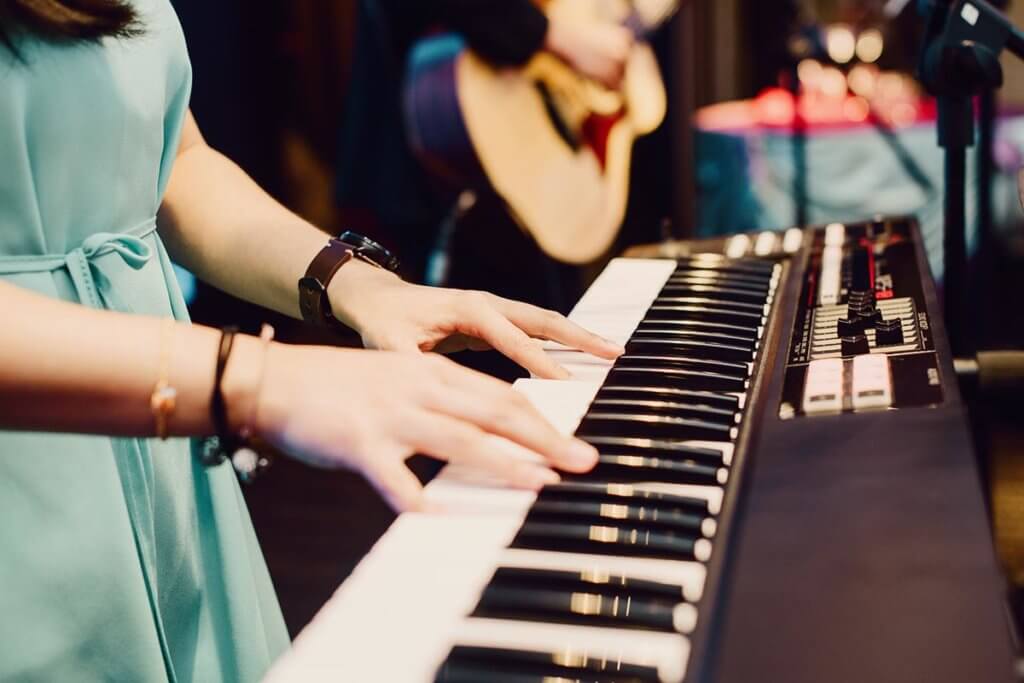 Frau am keyboard im Proberaum der Band
