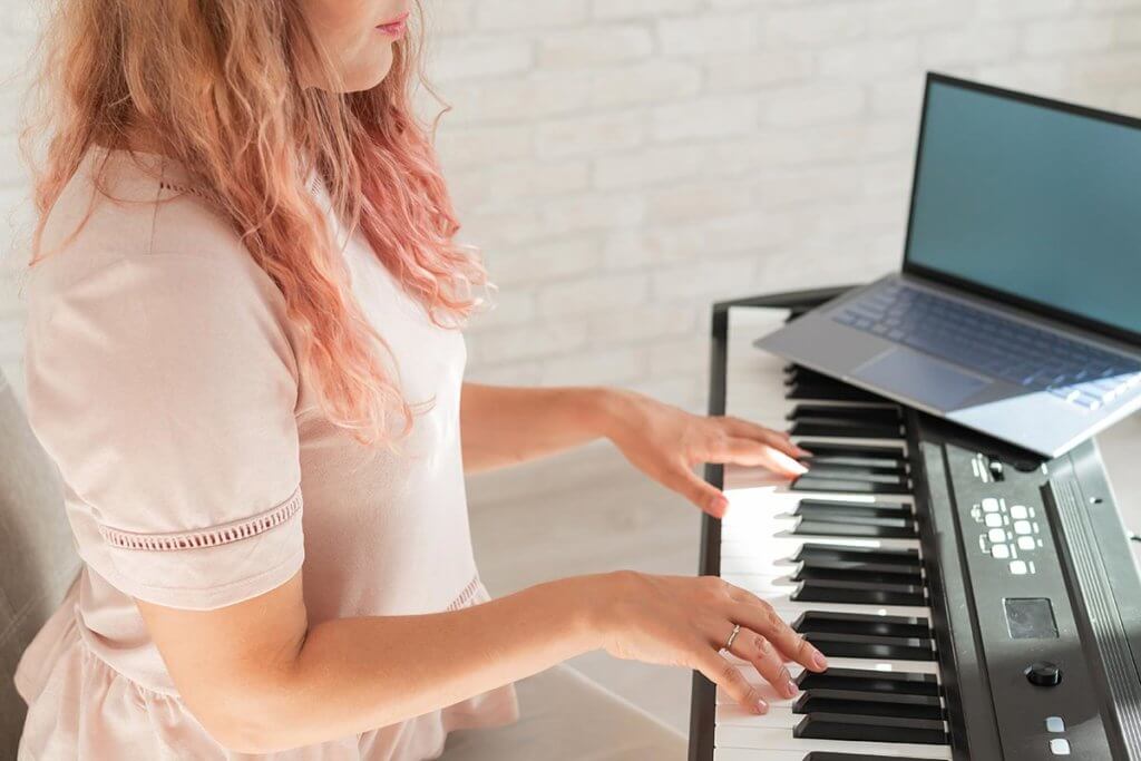 Frau am Keyboard mit Laptop