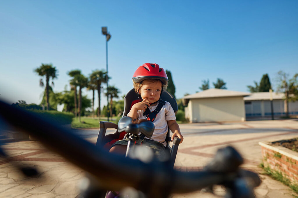 kleiner Junge auf Kindersitz beim Fahrradfahren