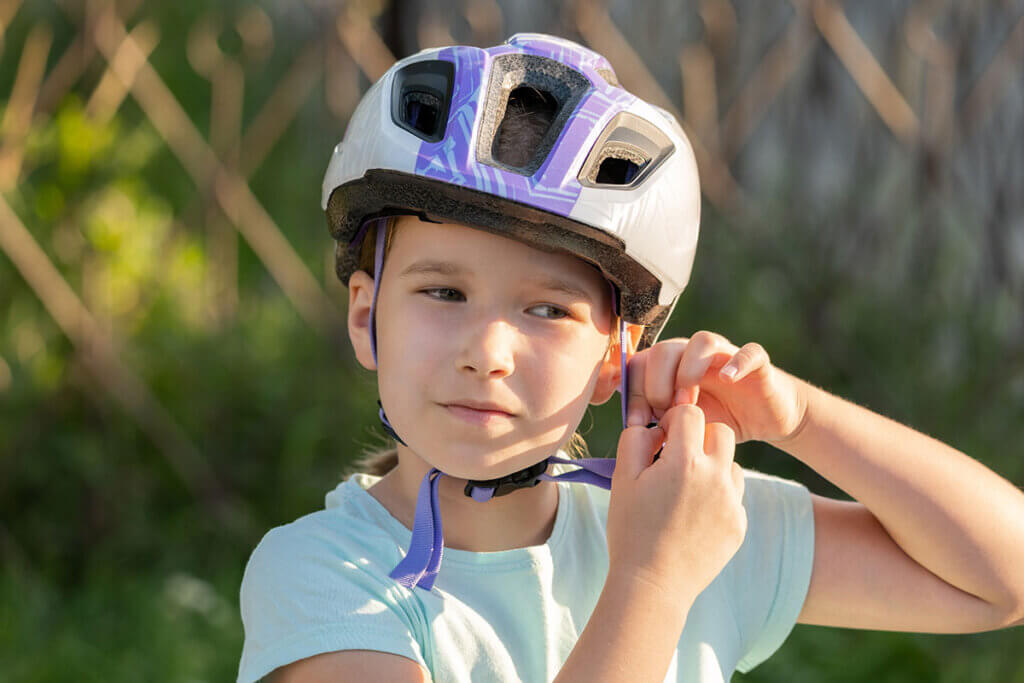 Kind setzt Fahrradhelm auf