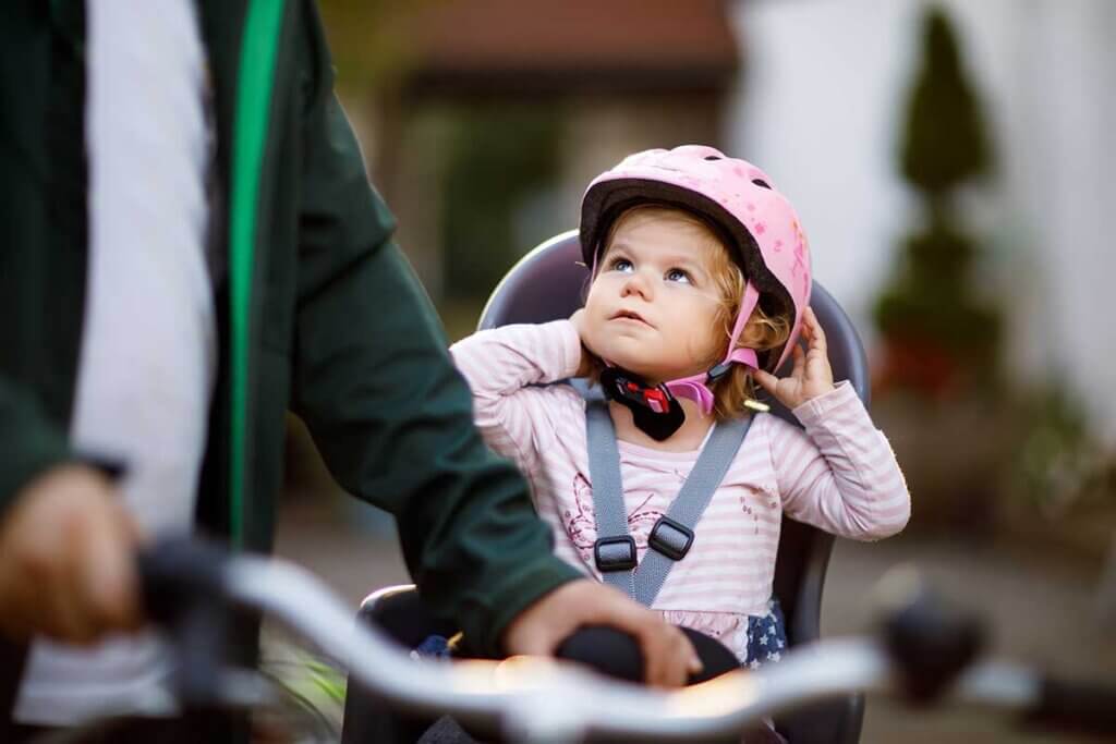 Mädchen in Fahrradsitz schaut zum Vater