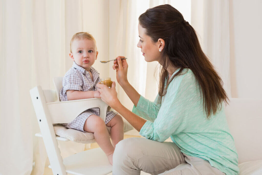 kleiner Junge wird von Mutter gefüttert