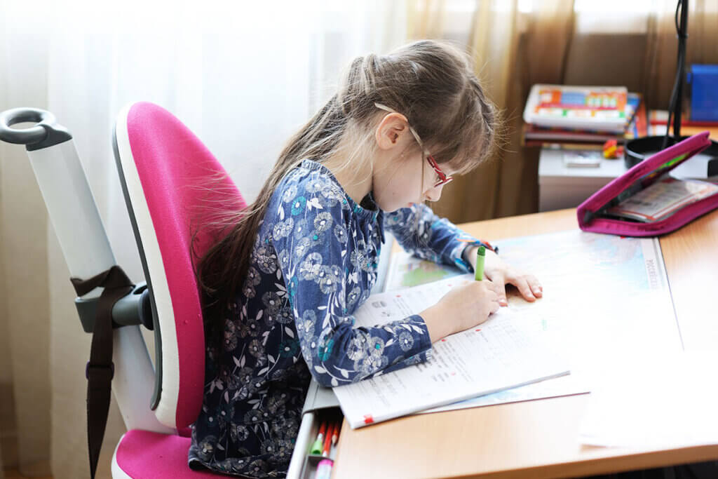 Kind macht Hausaufgaben am Schreibtisch