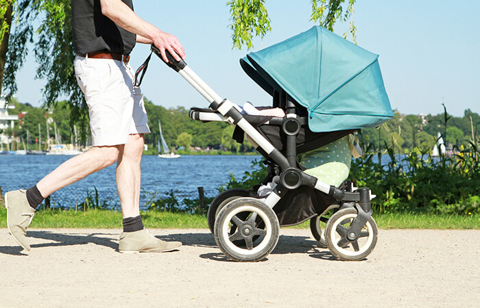 Vater schiebt Kinderwagen