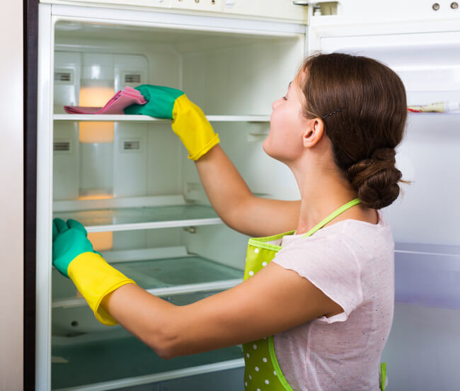Frau reinigt Kühlschrank