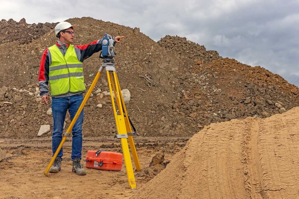 Arbeiter nutzt Laser-Entfernungsmesser auf Baustelle