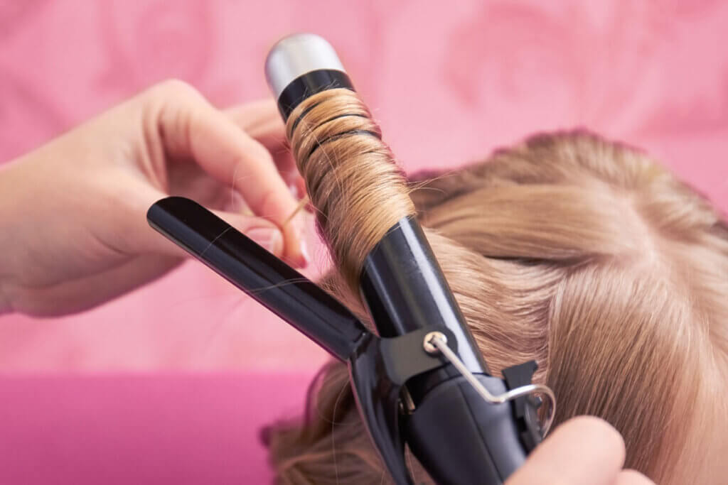 Anwendung von Lockenstab an blonden Haaren