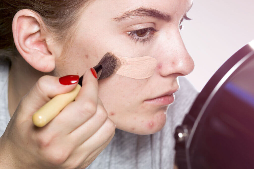 junge Frau trägt flüssiges Make-up auf