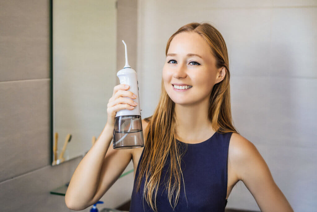 Frau hält Munddusche in Hand