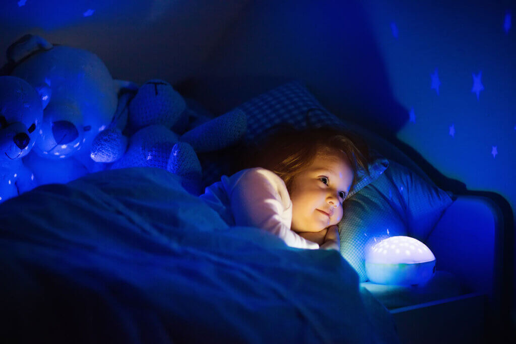 Kind mit Nachtlicht im Dunkeln