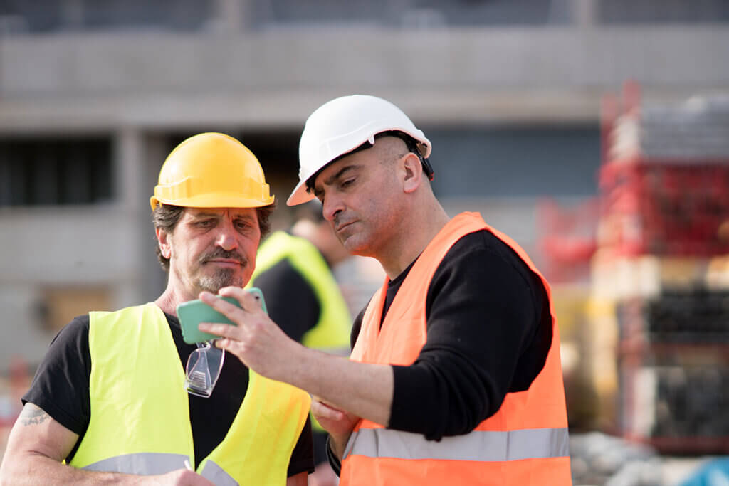 Bauarbeiter nutzen Smartphone auf Baustelle