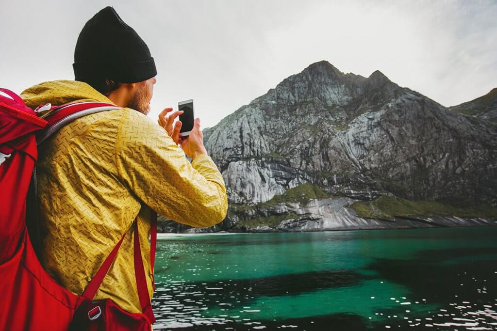 Mann schiesst Foto von See und Bergen